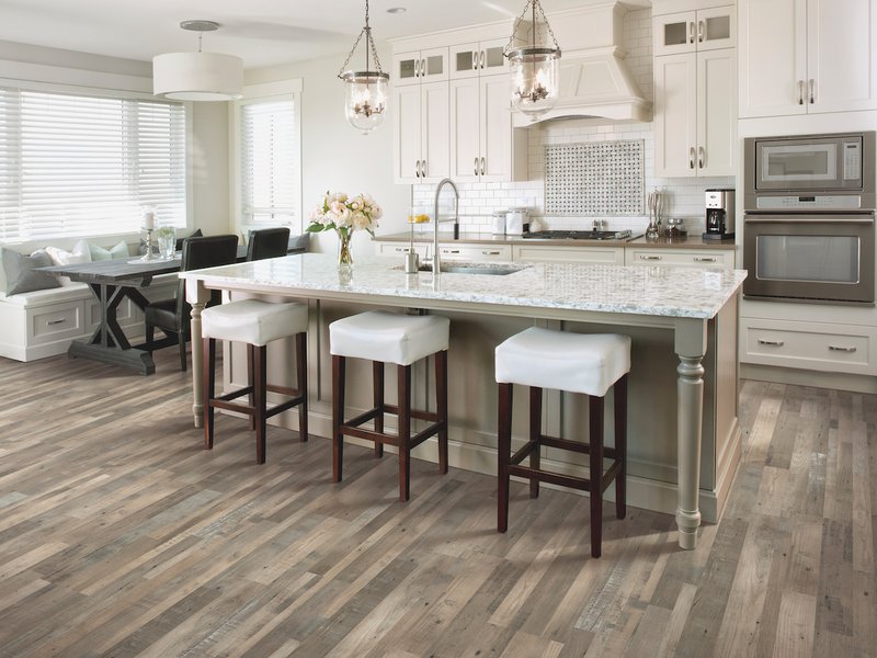 Kitchen with hard surface flooring, island with bar stools and tiled backsplash